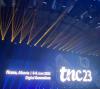 Beeld van het scherm van het podium van de TNC 2023 op de dag van de plenaire vergadering met de banner van TNC 2023.
